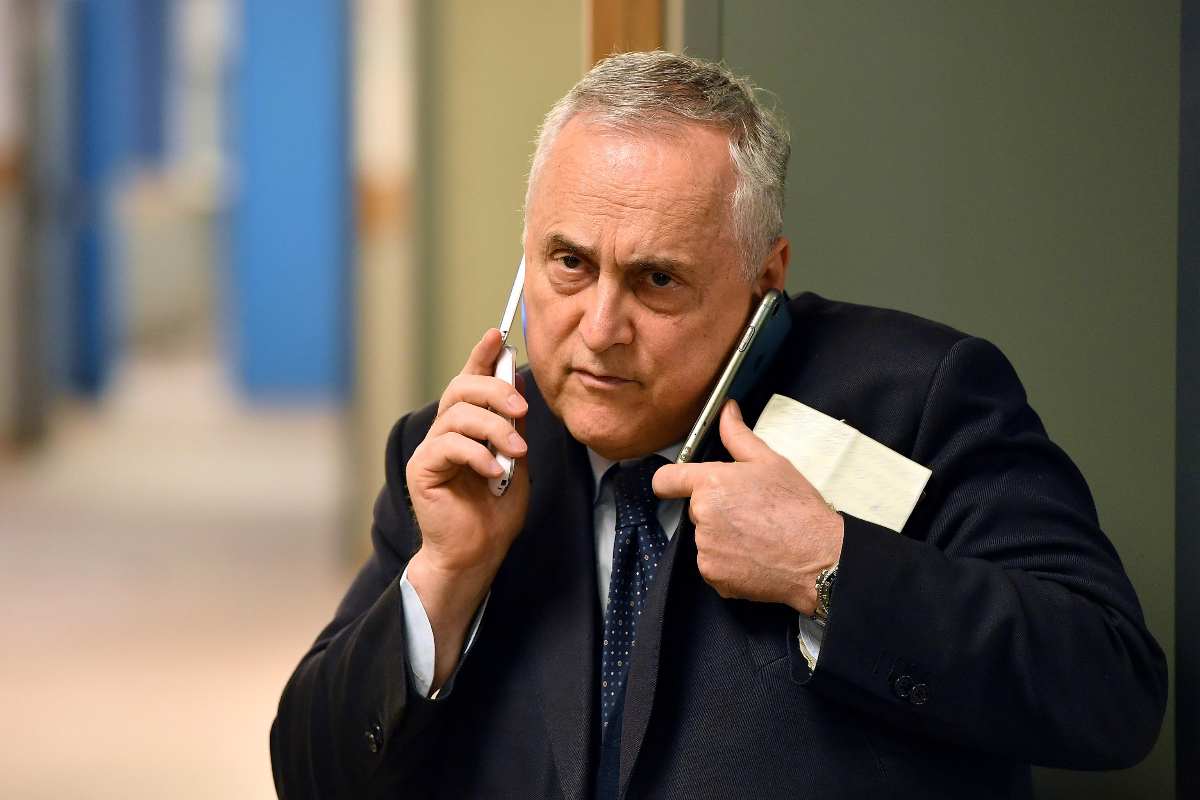 Claudio Lotito parla contemporaneamente con due telefoni alle orecchie